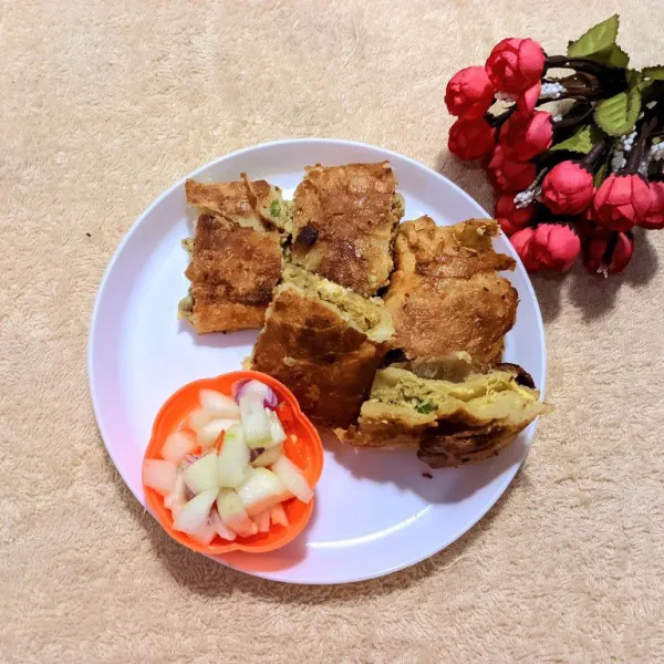 Potong martabak menjadi enam bagian. Sajikan martabak kari kambing dan ayam bersama acar timun.