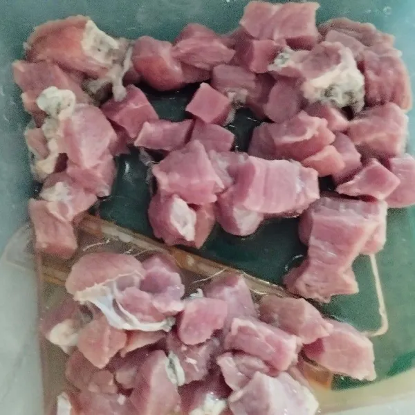 Cuci bersih daging kambing, lalu potong kotak kecil-kecil.