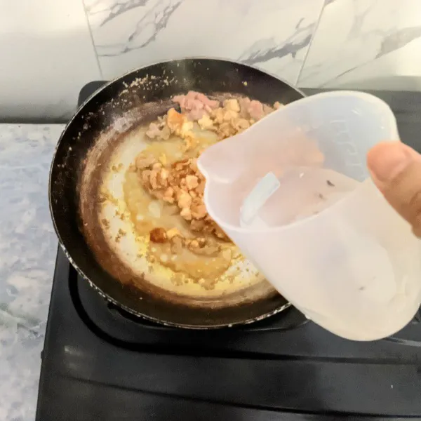 Tuangkan air secara perlahan lalu aduk rata. Biarkan sampai air menyusut.