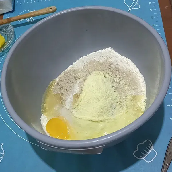 Campur terigu, gula pasir, susu bubuk, ragi dan telur aduk rata tuang air bertahap uleni sampai setengah kalis