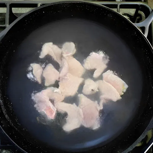 Rebus air dalam panci hingga mendidih. Masukkan irisan daging babi secara perlahan hingga daging matang sepenuhnya.