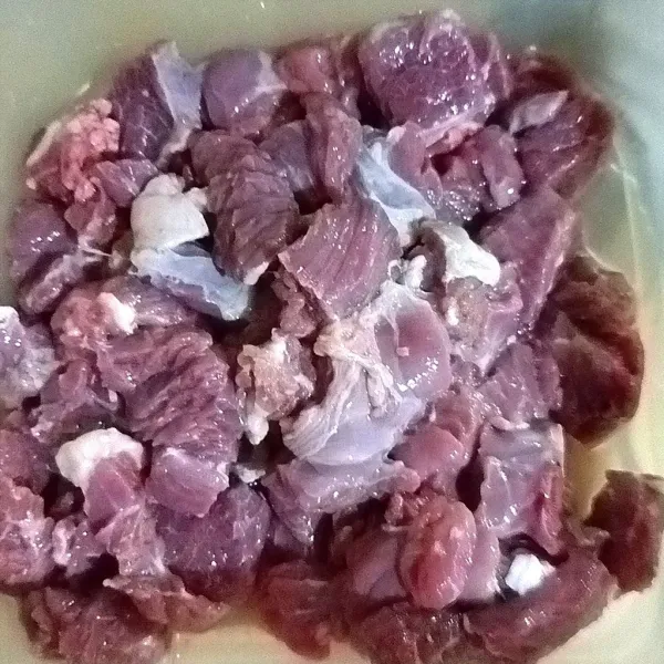 Cuci bersih daging, lalu potong-potong daging berbentuk dadu.