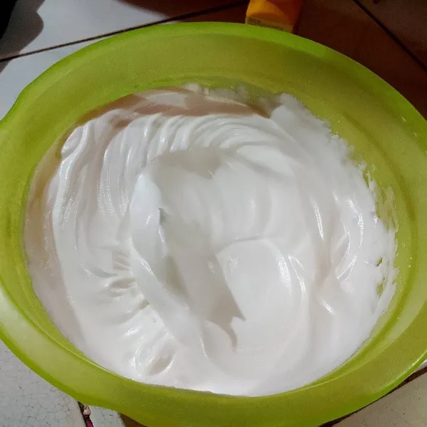 Mixer putih telur, garam, dan gula halus sampai mengembang putih kental (soft peak) apabila mixer diangkat dapat berbentuk jambul panjang.