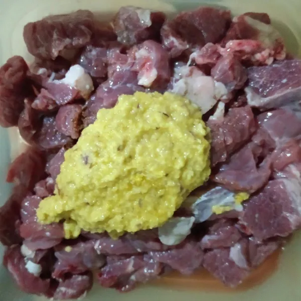 Beri kemiri, ketumbar, kunyit, bawang putih, bawang merah, dan minyak secukupnya sebagai bumbu marinasi yang sudah dihaluskan. Aduk rata.