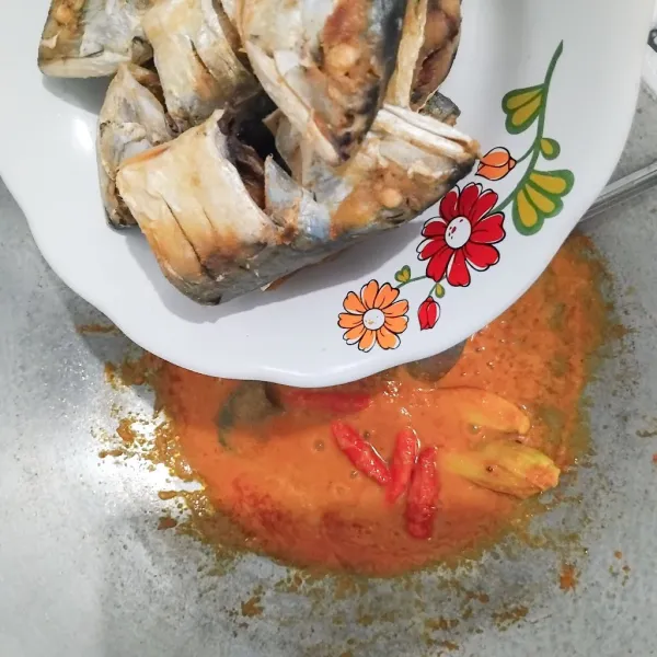 Masukkan potongan ikan kembung satu persatu diaduk rata ke bumbu