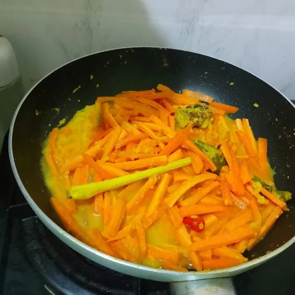 Masukkan wortel dan air, masak sampai agak empuk.