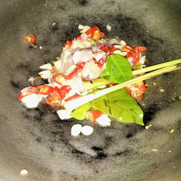 Kemudian, tumis bumbu yang sudah diiris tipis, lalu tambahkan daun jeruk, daun salam, dan serai. Aduk hingga rata.