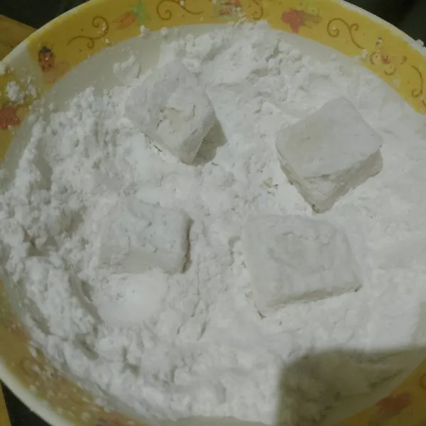 Campur tapioka dengan garam, baluri tahu dengan tapioka sampai tertutup rapat.