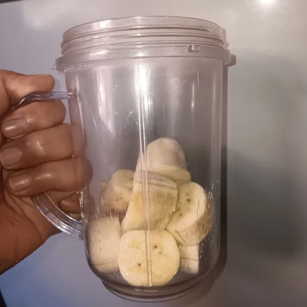 Kupas pisang, potong-potong, lalu masukkan ke gelas blender.