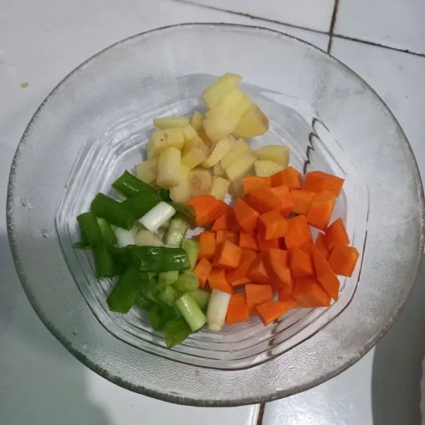 Potong-potong wortel, kentang, dan daun bawang sesuai selera.