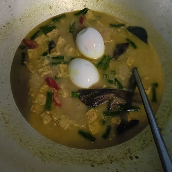 Masukkan irisan cabe merah dan telur rebus, masak sampai matang