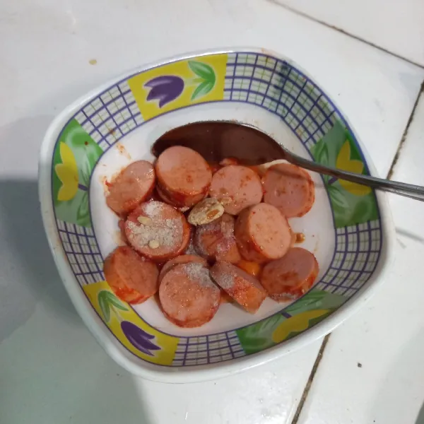 Potong sosis, lalu tambahkan saus gochujang, lada bubuk, bawang putih bubuk, penyedap rasa, dan garam.