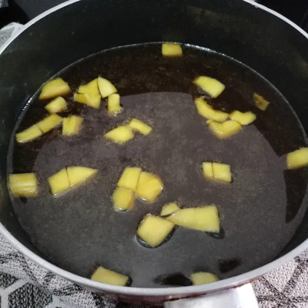Langkah pertama, rebus gula merah dan gula pasir hingga matang. Campurkan sedikit irisan nangka, kemudian aduk sampai rata.