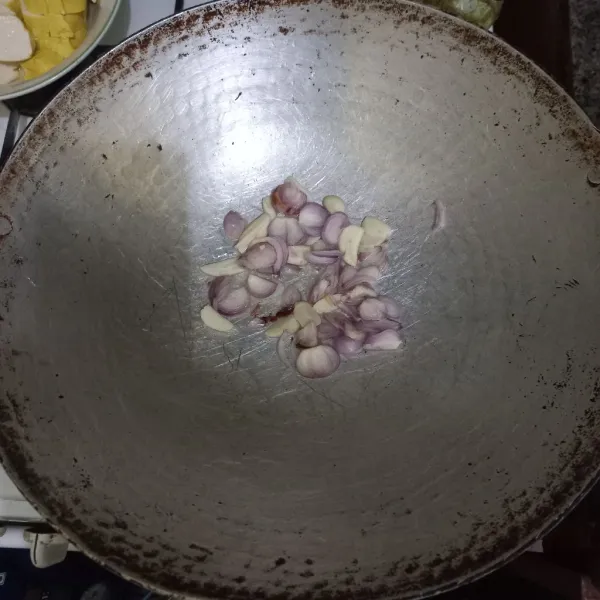Tumis irisan bawang merah dan bawang putih hingga harum.