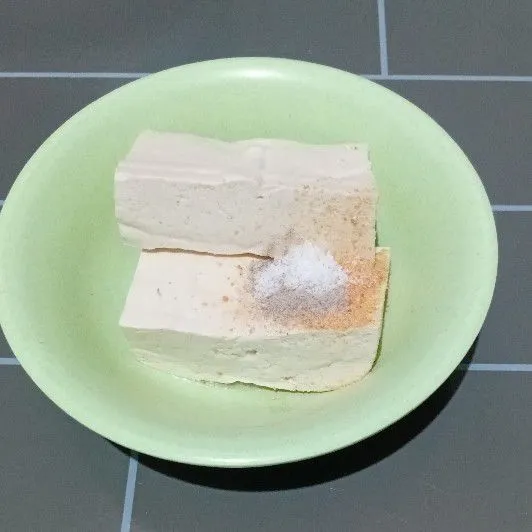 Siapkan tahu dalam wadah, masukkan bumbu, lalu lumatkan hingga rata.
