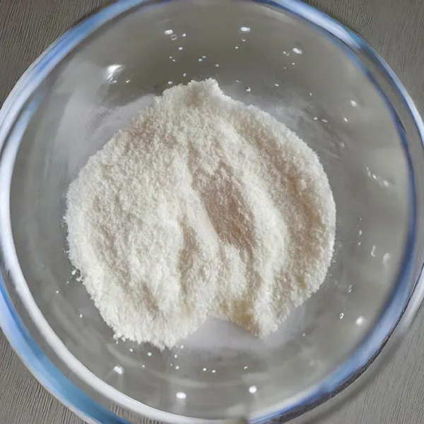 Campurkan 80 gr kelapa parut kering dan 80 gr tepung terigu dalam wadah terpisah, kemudian aduk rata. Masukkan campuran kelapa dan tepung ke dalam adonan margarin, aduk hingga menjadi adonan yang padat dan lembut.