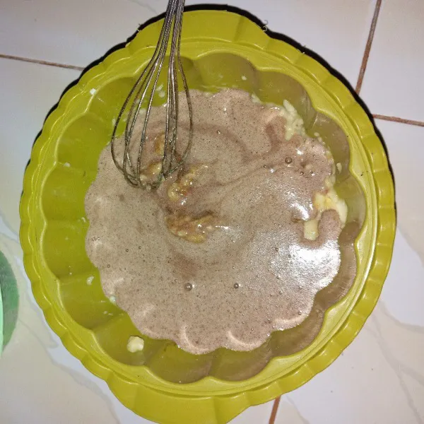 Setelah semua bahan telah tercampur rata, tuanglah kedalam loyang yang ada pisangnya.