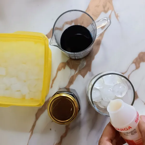 Masukkan es batu dan minuman probiotik.