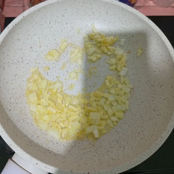 Panaskan margarin, lalu tumis bawang bombay. Masukkan bawang putih cincang.
