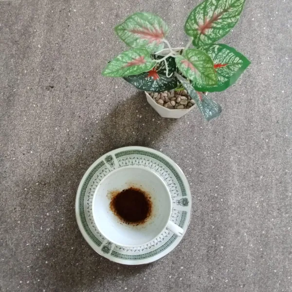 Siapkan gelas saji, masukkan bubuk kopi hitam tanpa ampas.