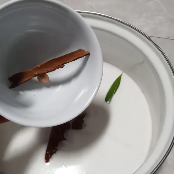 Tambahkan kayu manis, daun pandan, dan kapulaga. Masak hingga santan mendidih, jangan lupa diaduk agar santan tidak pecah.