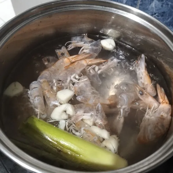 Setelah mendidih, masukkan kulit udang. Rebus sampai air berubah warna.