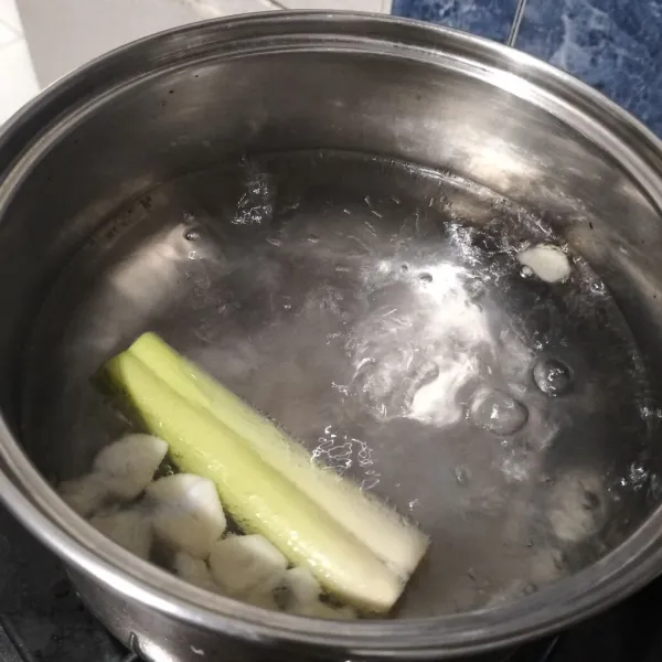 Didihkan air dalam panci bersama bawang putih dan serai.