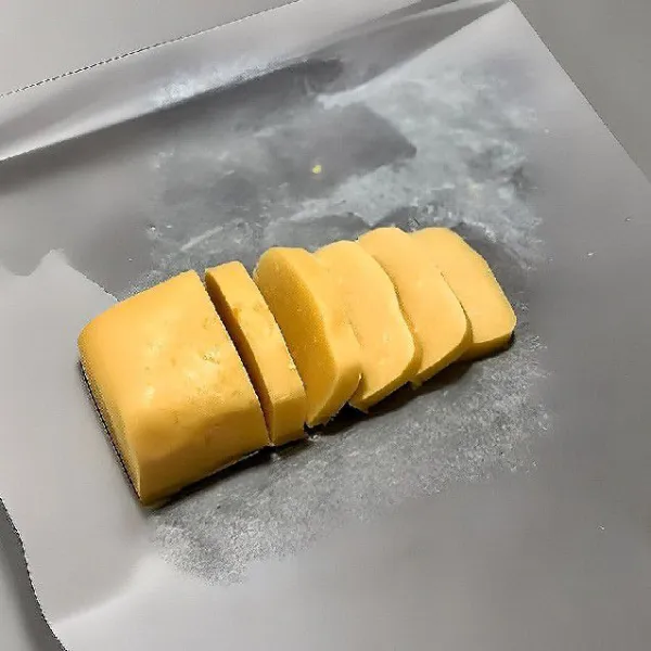 Bentuk adonan memanjang seperti balok, bungkus menggunakan kertas roti, simpan adonan di dalam freezer. Keluarkan adonan, potong-potong dengan ketebalan sekitar 0,5–1 cm.