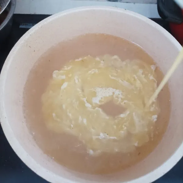 Didihkan air. Setelah mendidih, masukkan kocokan telur sambil terus diaduk secara perlahan.