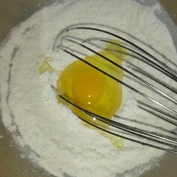 Campur tepung terigu, garam, baking powder, baking soda, gula pasir, dan vanili bubuk. Kemudian, aduk rata. Tambahkan telur dan air, lalu aduk rata.