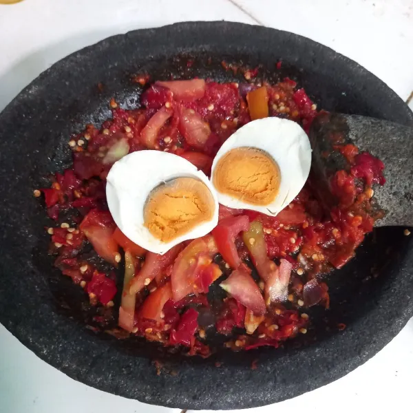 Tambahkan telur asin dan tekan tekan telur menggunakan ulekan.