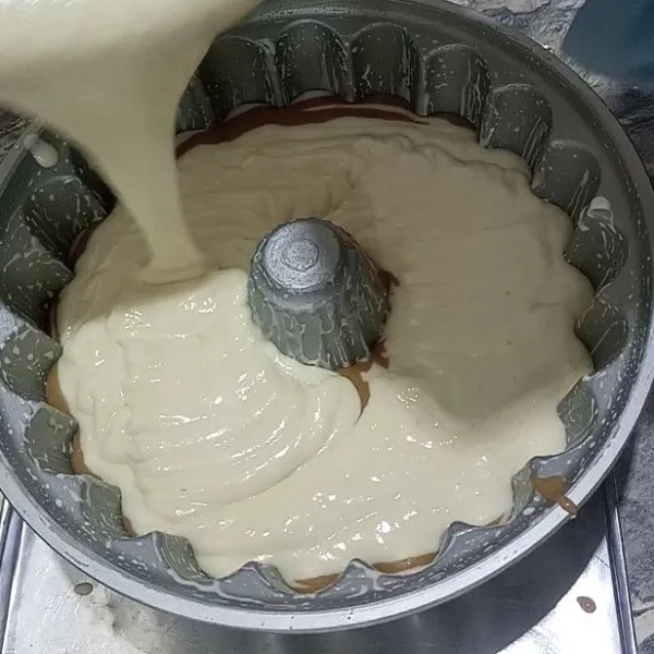 Beri adonan putih di atasnya lalu tuang lagi adonan coklat begitu terus selang seling sampai adonan habis
