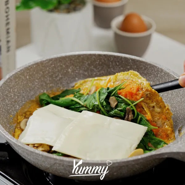 Panaskan minyak masukkan telur, wortel, dan letakkan semua bahan di atasnya masak hingga matang.