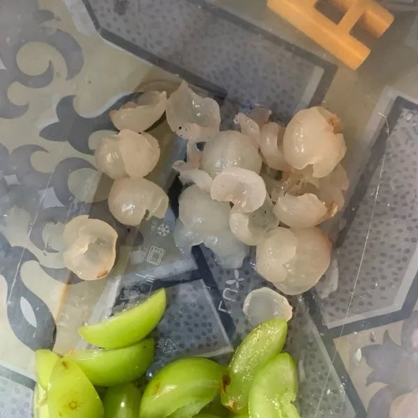 Kupas kelengkeng, lalu potong jadi 2 bagian