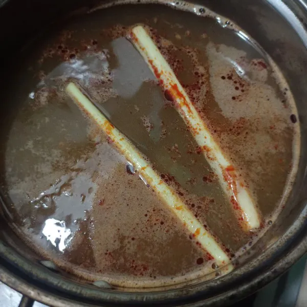 Masukkan ke dalam panci kaldu udang, serai, dan bumbu instan tomyum.