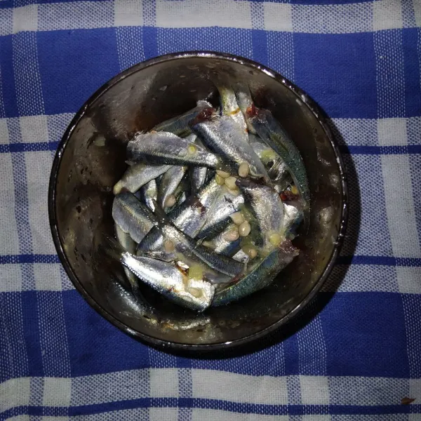 Bersihka ikan dari sisik, kotoran perut dan kepalanya. Cuci bersih, lalu beri air perasan jeruk nipis, lalu marinasi selama 5 menit.
