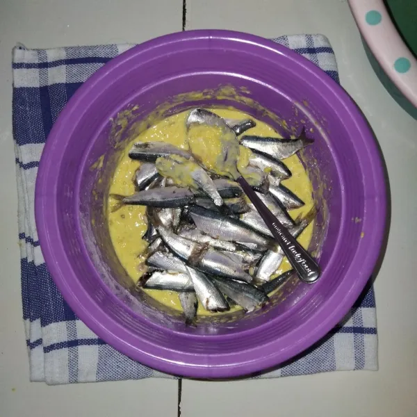 Masukkan ikan sarden yang sudah dimarinasi sebelumnya, lalu aduk hingga tercampur secara merata dengan adonan tepung.