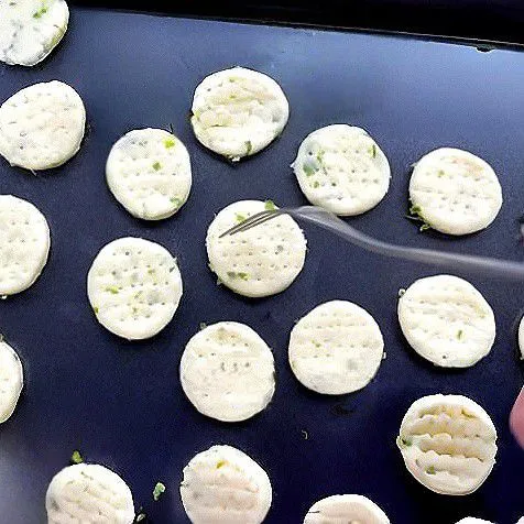 Susun potongan adonan di atas loyang yang telah dialasi kertas baking atau dioles sedikit minyak. Gunakan garpu kecil untuk menusuk-nusuk bagian tengah adonan.