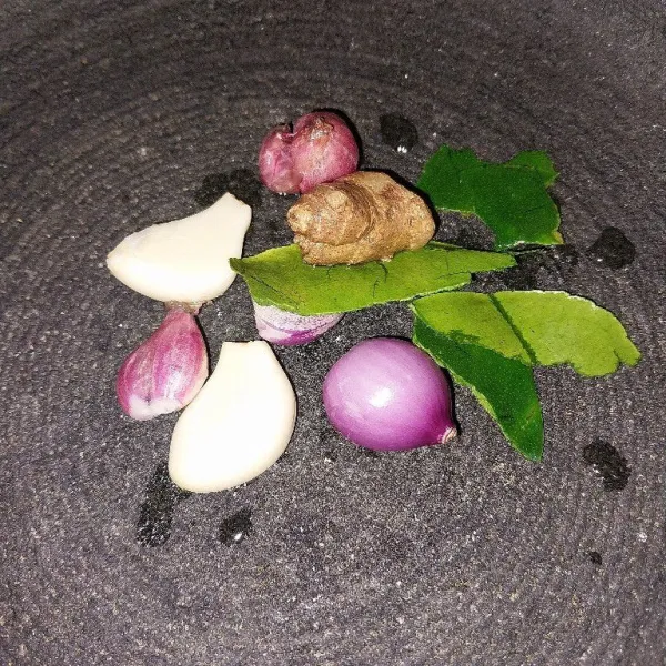 Haluskan bawang merah, bawang putih, kencur, dan daun jeruk sebagai bahan bumbu, lalu rebus air hingga mendidih.