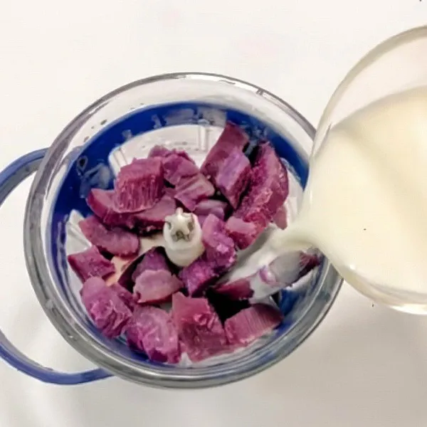 Masukkan ubi ungu kukus ke dalam food processor. Tambahkan susu bubuk dan susu cair ke dalam blender bersama ubi. Haluskan hingga teksturnya lembut dan tidak bergerindil.