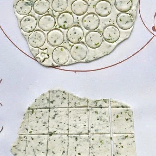 Setelah mengembang, kempiskan adonan dan pipihkan adonan. Cetak adonan dengan cetakan bulat atau potong menjadi kotak kecil.