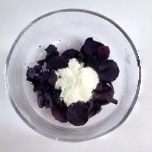 Kukus ubi ungu sampai empuk, lalu haluskan. Tambahkan susu bubuk ke dalam ubi yang telah dihaluskan, aduk rata hingga menjadi adonan lembut.