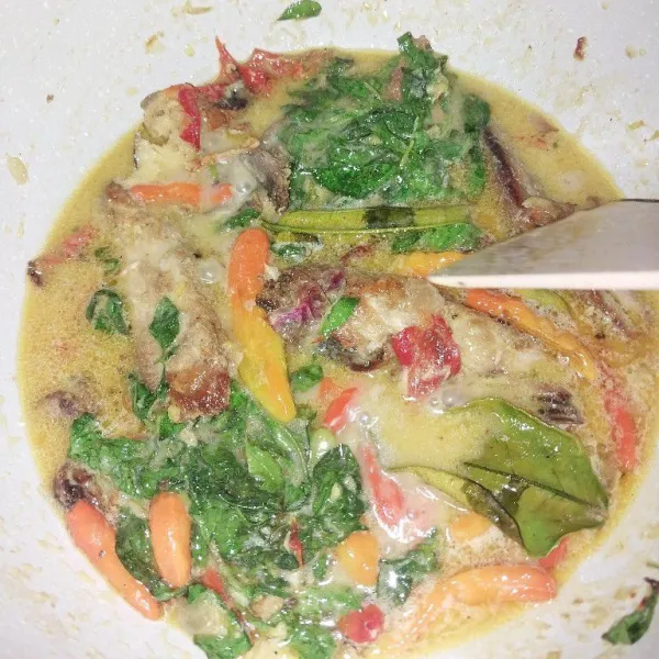 Masukkan daun kemangi, lalu masak hingga layu.