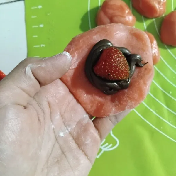 Ambil satu persatu kulit mochi, beri isian filling coklat dan strawbery lalu tutup rapat.