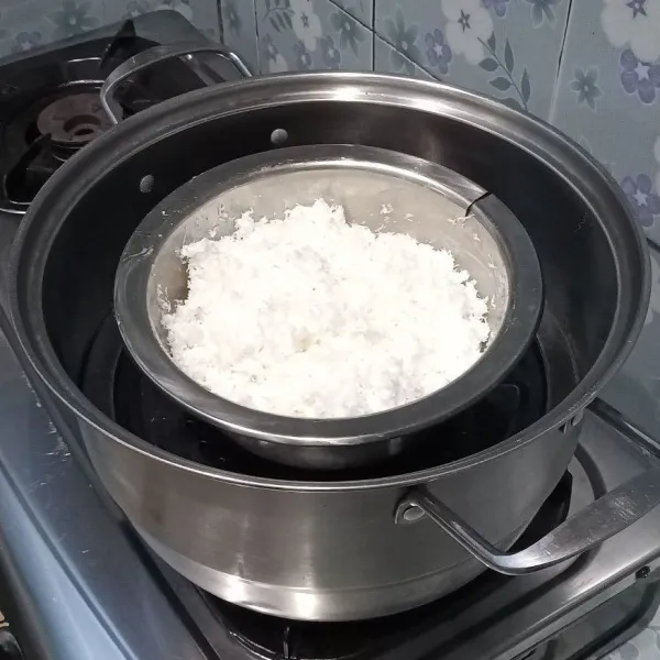 Siapkan kelapa parut, lalu campurkan dengan tepung maizena dan garam. Kemudian kukus sampai matang.