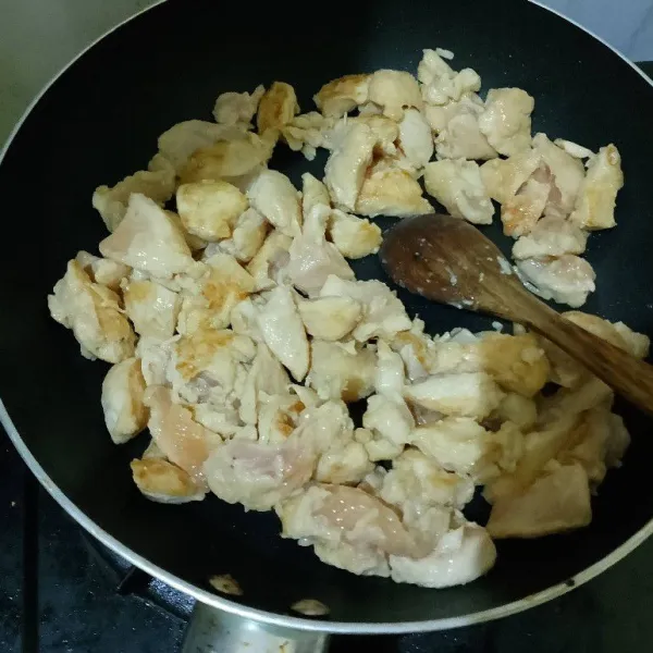 Masukkan ayam, masak hingga berubah warna, lalu masukkan bawang putih dan tumis sampai wangi.