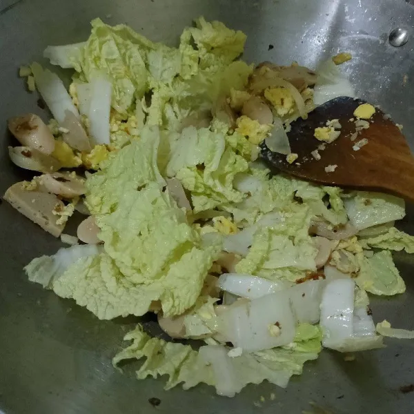 Masukkan sawi, lalu masak sampai layu.