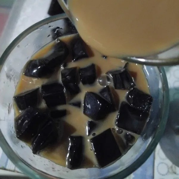 Tuangkan larutan kopi cappucino ke dalam gelas yang sudah diisi cincau.