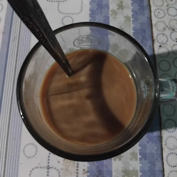 Seduh kopi cappucino instan dan kental manis putih dengan air panas, aduk hingga larut dan biarkan dingin.