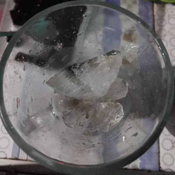 Siapkan gelas saji, masukkan es batu.